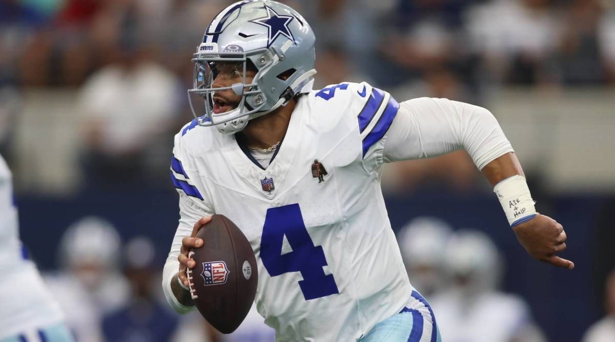 Cowboys quarterback Dak Prescott runs with the football in a game.