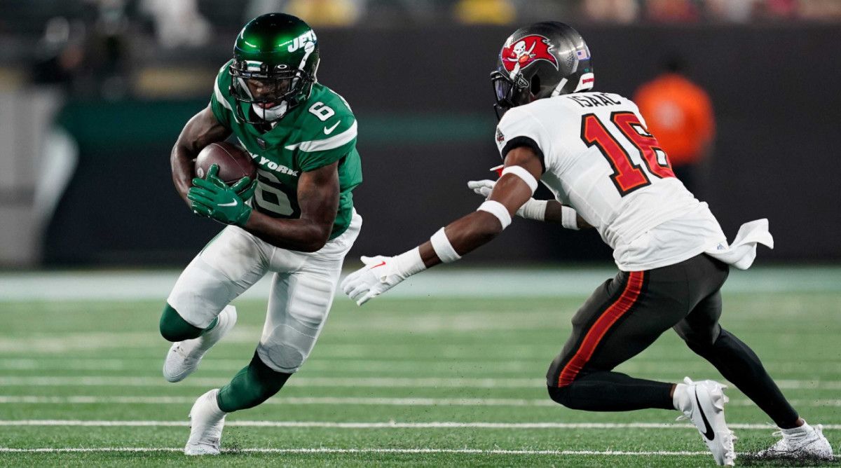 Jets wide receiver runs the ball with pressure from Buccaneers cornerback Keenan Isaac.