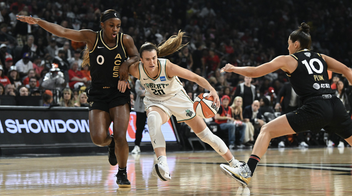 New York Liberty guard Sabrina Ionescu drives past Las Vegas Aces guards Jackie Young and Kelsey Plum in Game 1 of the WNBA Finals.