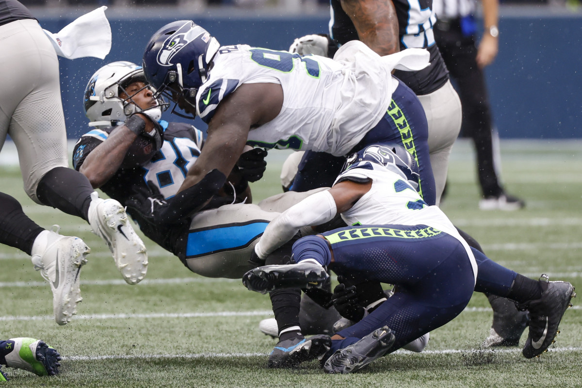 Seattle Seahawks defensive tackle Jarran Reed (90) assists cornerback Artie Burns (23) on a tackle of Carolina Panthers wide receiver Terrace Marshall Jr. (88) during the fourth quarter at Lumen Field.