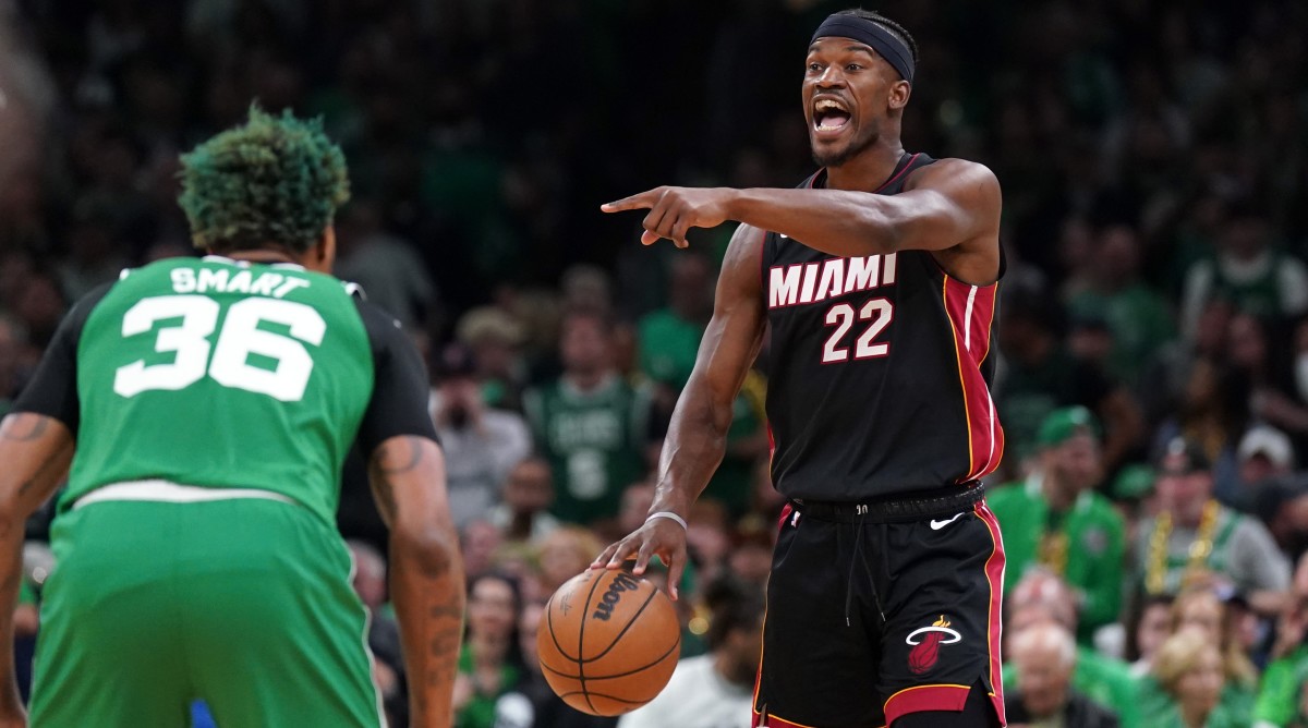Heat forward Jimmy Butler dribbles the ball with Celtics guard Marcus Smart defending.