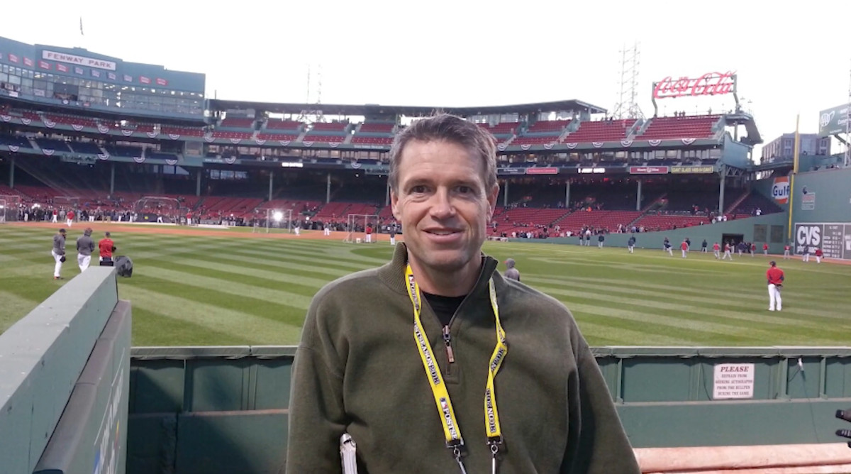 Former baseball writer Jim Caple poses with the inside of Fenway Park in the background.