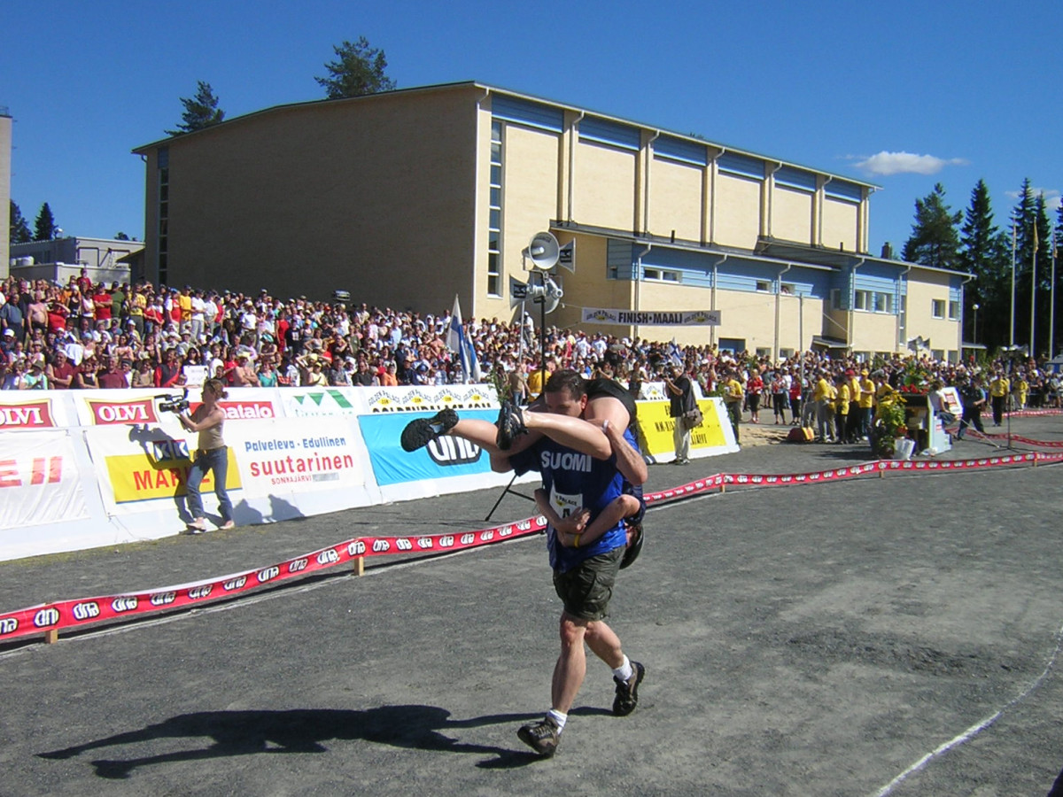 Vicki Schuman clings to husband Jim Caple to him like an inverted backpack while racing as one in the Wife Carrying World Championships in Sonkajärvi, Finland.