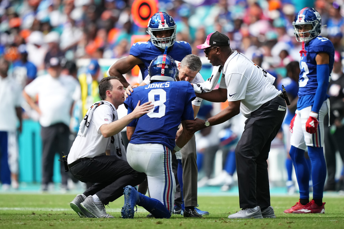 New York Giants team trainers attend to New York Giants quarterback Daniel Jones (8) after an apparent injury during the second half agianst the Miami Dolphins at Hard Rock Stadium.