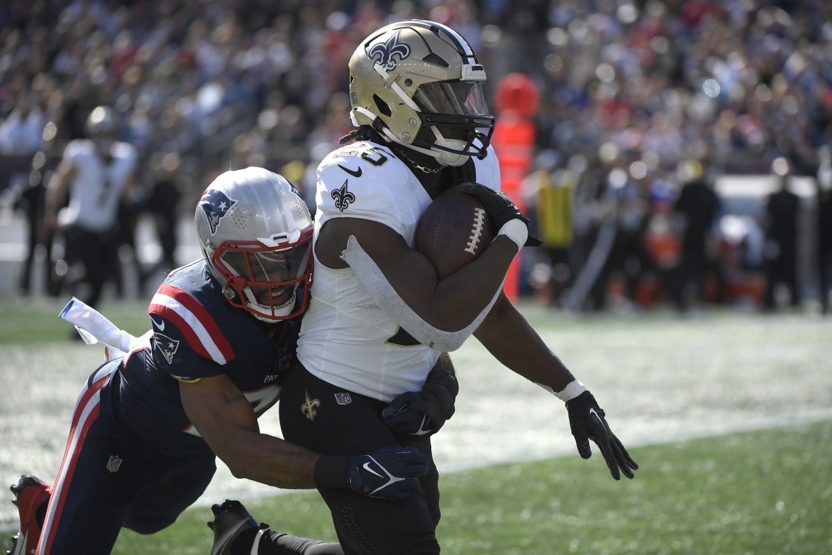 Oct 8, 2023; New England Patriots safety Adrian Phillips (21) tackles New Orleans Saints running back Kendre Miller (25) after a big gain. Mandatory Credit: Bob DeChiara-USA TODAY Sports
