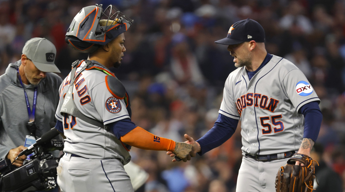 Astros relief pitcher Ryan Pressly (right) shakes hands with catcher Martín Maldonado after the ninth inning of Game 4 of the ALDS.