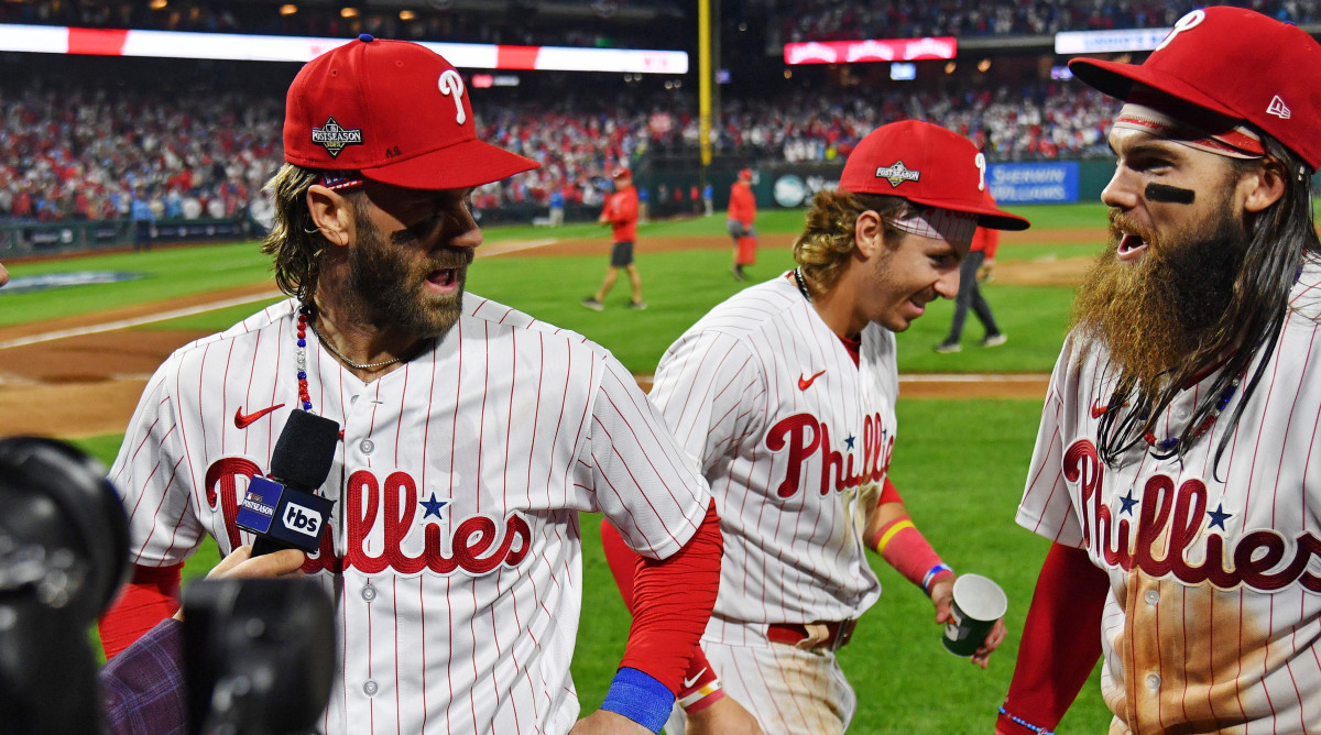 Phillies first baseman Bryce Harper (left) celebrates with second baseman Bryson Stott (center) and left fielder Brandon Marsh (right) after beating the Braves in Game 3 of the 2023 NLDS.