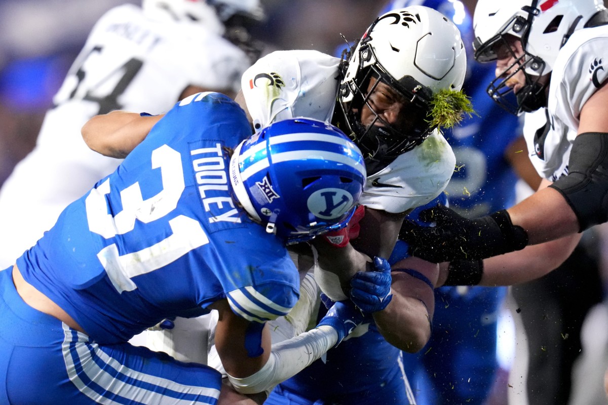 Cincinnati Bearcats running back Corey Kiner (21) is tackled by Brigham Young Cougars linebacker Max Tooley (31) in the third quarter during a college football game between the Brigham Young Cougars and the Cincinnati Bearcats, Saturday, Sept. 30, 2023, at LaVell Edwards Stadium in Provo, Utah.