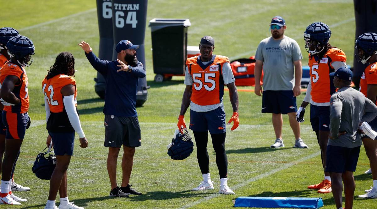 The Broncos linebackers stand around pass rusher Frank Clark during a training camp practice.
