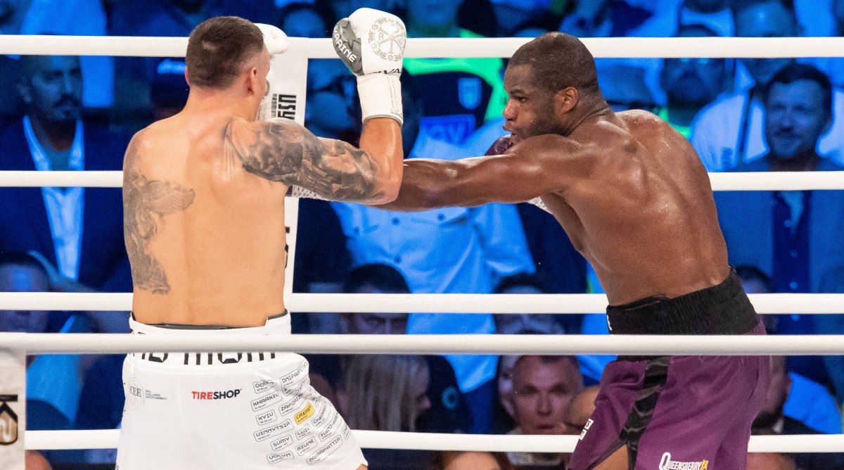 Daniel Dubois throws a punch at Oleksandr Usyk during a boxing match.