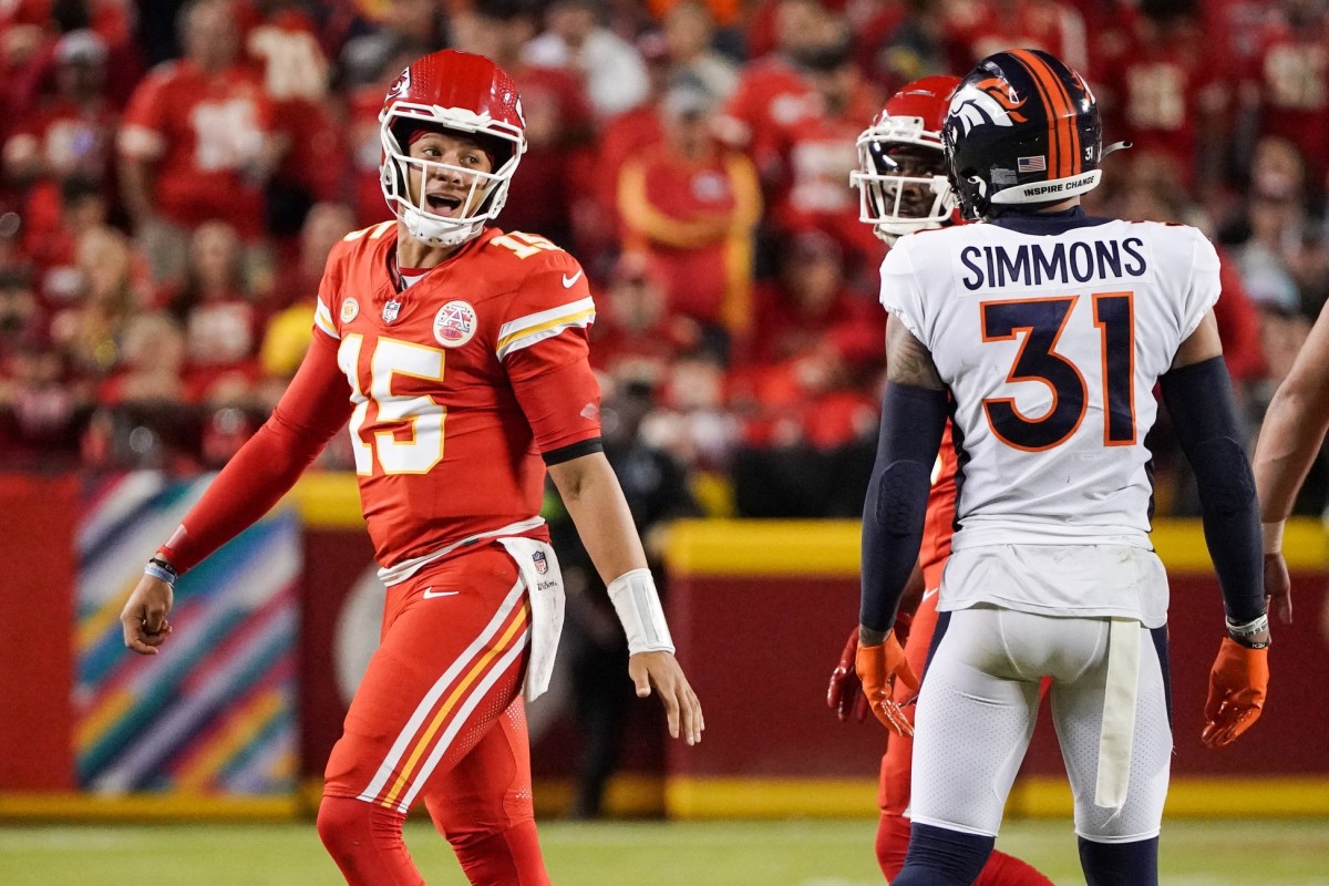 Kansas City Chiefs quarterback Patrick Mahomes (15) speaks to Denver Broncos safety Justin Simmons (31) after a play during the first half at GEHA Field at Arrowhead Stadium.