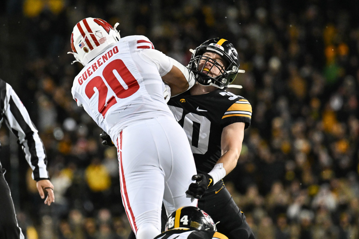 Nov 12, 2022; Iowa City, Iowa, USA; Iowa Hawkeyes defensive back Quinn Schulte (30) and Wisconsin Badgers running back Isaac Guerendo (20) in action during the game at Kinnick Stadium. Mandatory Credit: Jeffrey Becker-USA TODAY Sports