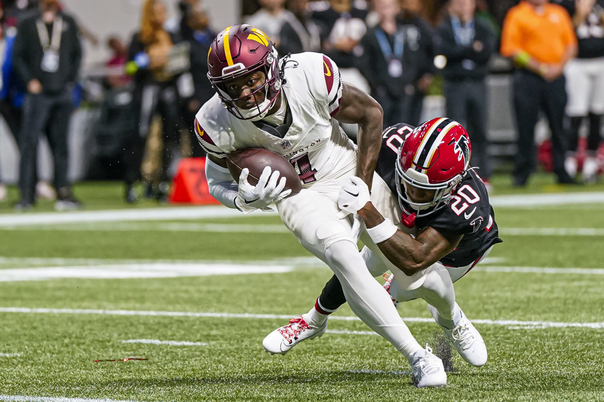 Washington Commanders wide receiver Curtis Samuel (4) runs through Atlanta Falcons cornerback Dee Alford (20) for a touchdown during the first half at Mercedes-Benz Stadium.