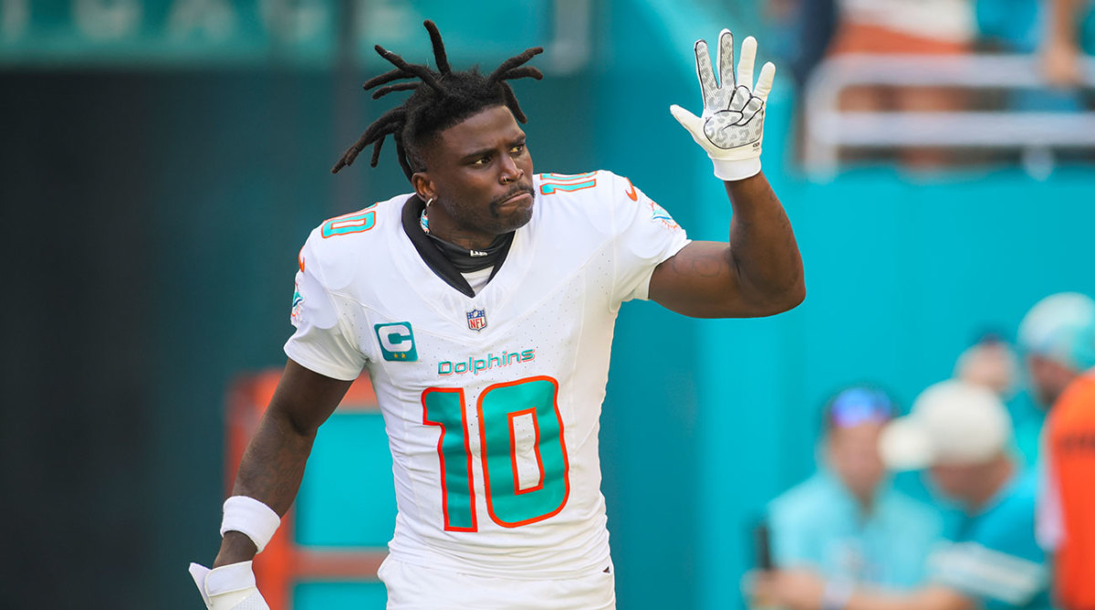 Tyreek Hill raises his hand while on the field pregame with his helmet off