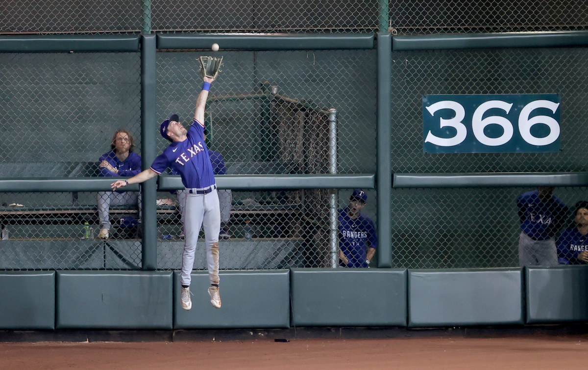 Texas Rangers center fielder Evan Carter (32) makes a catch at the wall during the eighth inning of game one of the ALCS against the Houston Astros in the 2023 MLB playoffs at Minute Maid Park.