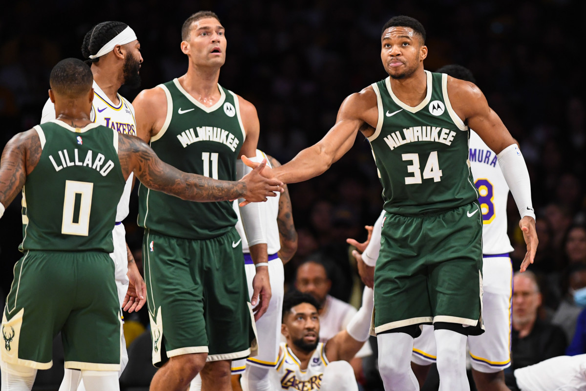 Milwaukee Bucks forward Giannis Antetokounmpo (34) celebrates with guard Damian Lillard (0) and center Brook Lopez (11) against the Los Angeles Lakers 