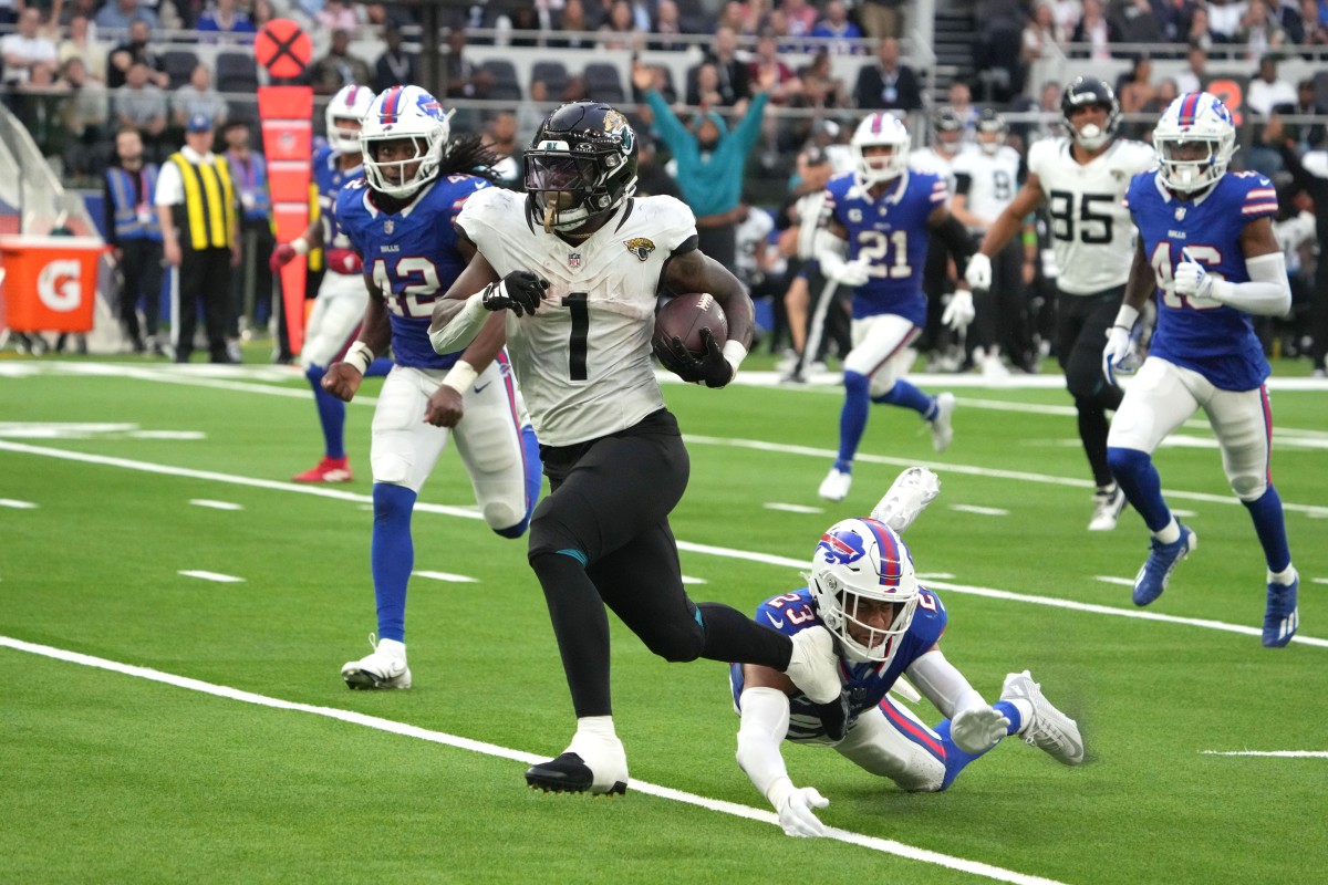 Oct 8, 2023; Jacksonville Jaguars running back Travis Etienne Jr. (1) outruns Buffalo Bills safety Micah Hyde (23) on a 35-yard touchdown run. Mandatory Credit: Kirby Lee-USA TODAY Sports