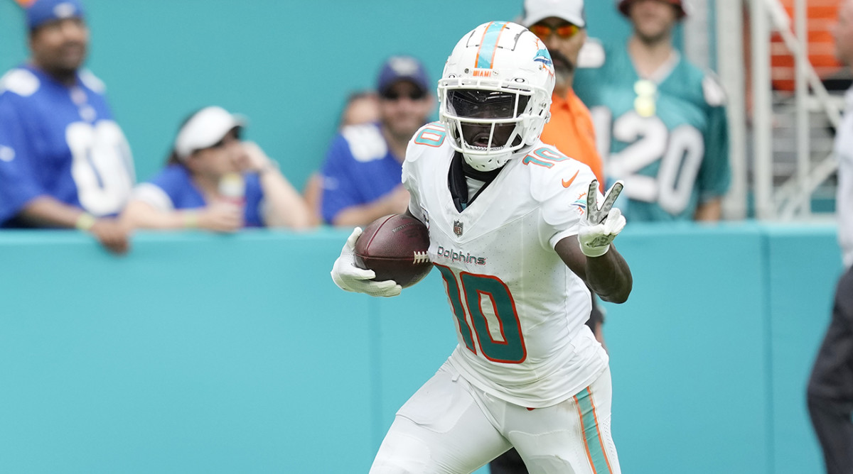 Dolphins wide receiver Tyreek Hill (10) gestures as he runs for a touchdown.