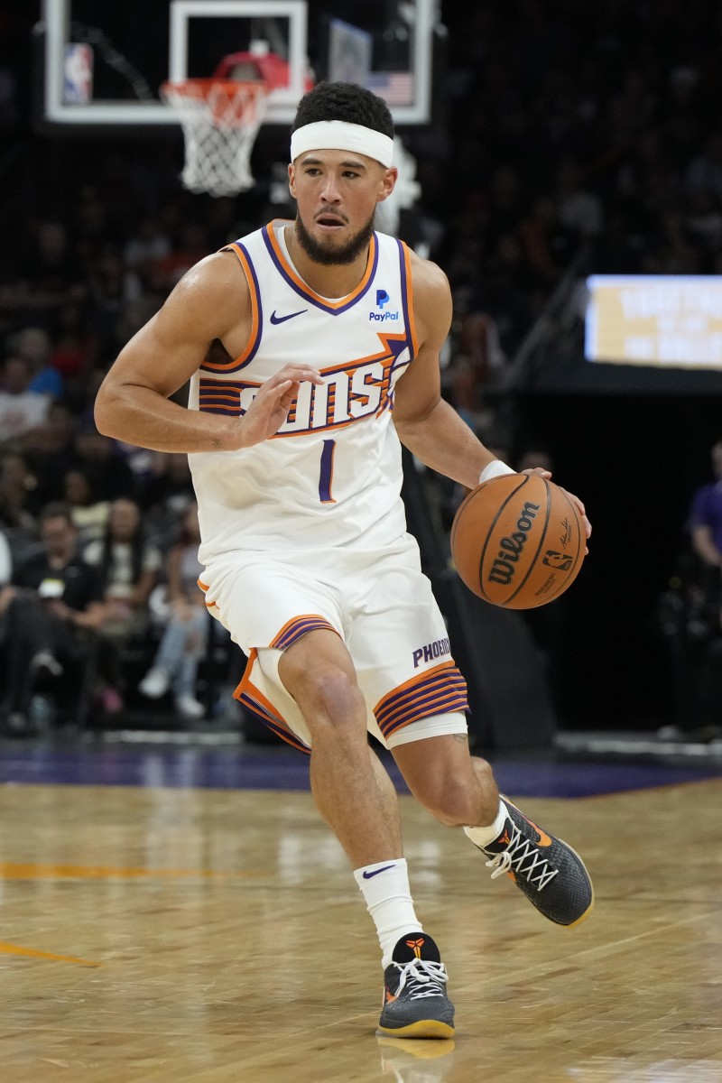 Phoenix Suns guard Devin Booker dribbles up court