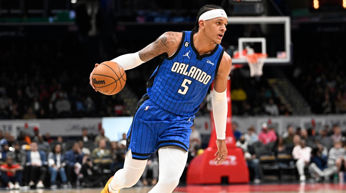 Magic forward Paolo Banchero (5) dribbles the ball against the Wizards during a game.