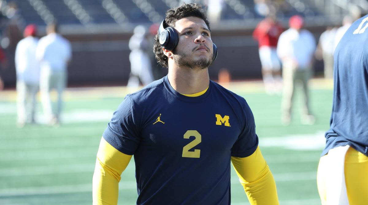 Michigan running back Blake Corum warms up with headphones before a game.