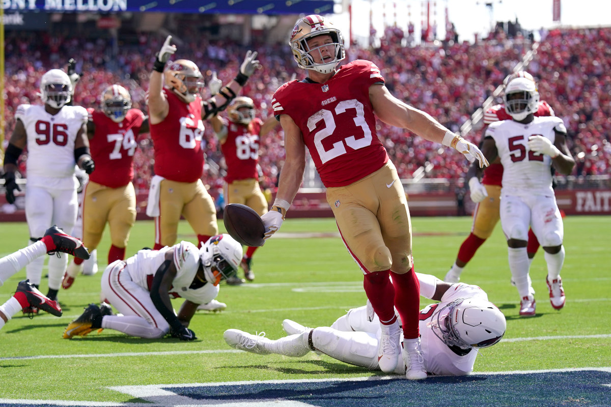 Christian McCaffrey holds the ball out after scoring a touchdown against the Cardinals.