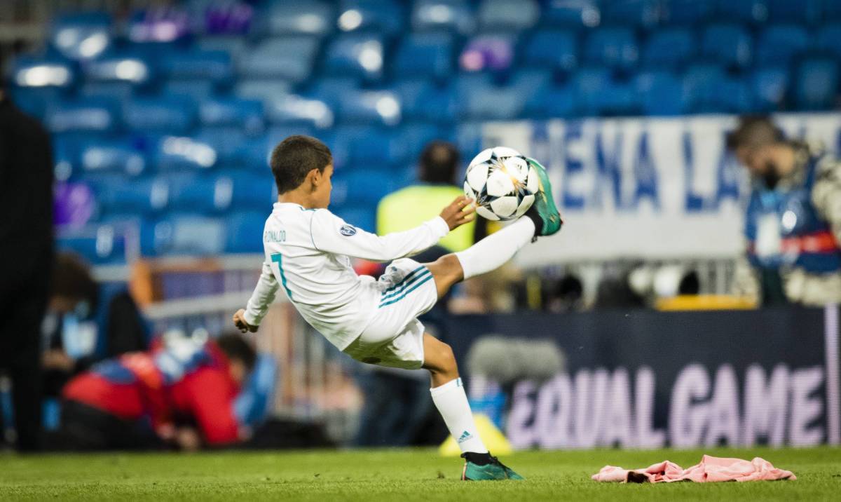 Cristiano Ronaldo Jr pictured performing an overhead kick on the pitch at the Bernabeu Stadium after a UEFA Champions League game between Real Madrid and Bayern Munich in 2018