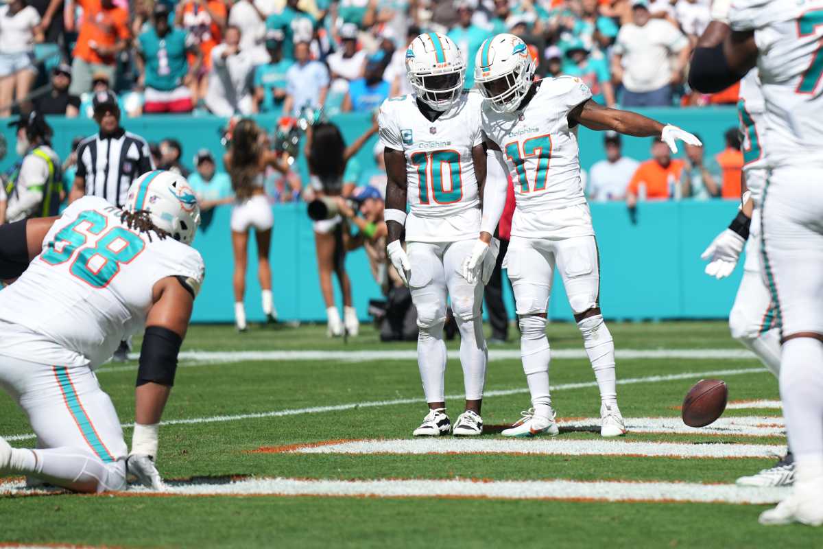 Tyreek Hill stands next to Jaylen Waddle, who drops the ball in the end zone as celebration