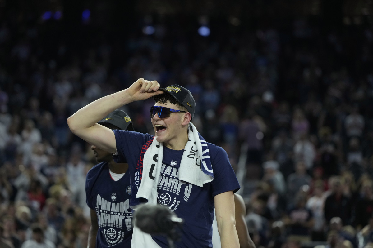 Donovan Clingan holds onto the hat on his head after winning the national championship in 2023