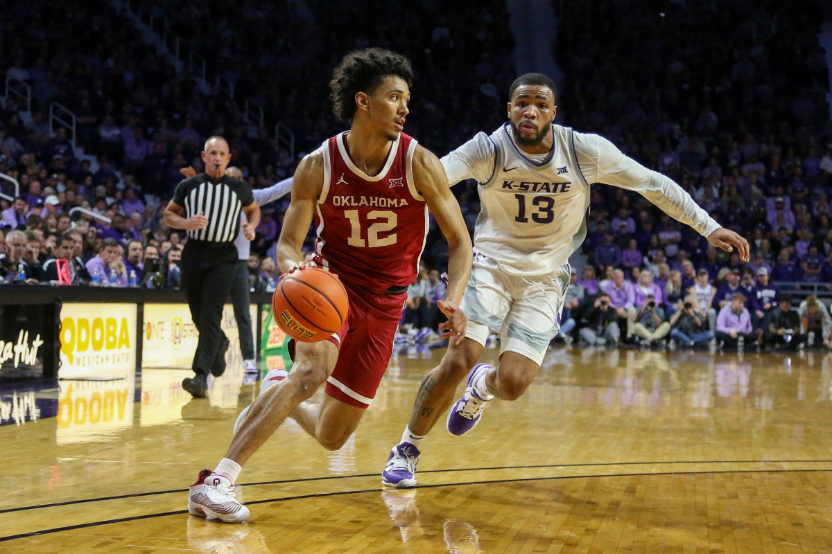 Milos Uzan dribbles as Kansas State Wildcats guard Desi Sills runs behind him to try to catch up