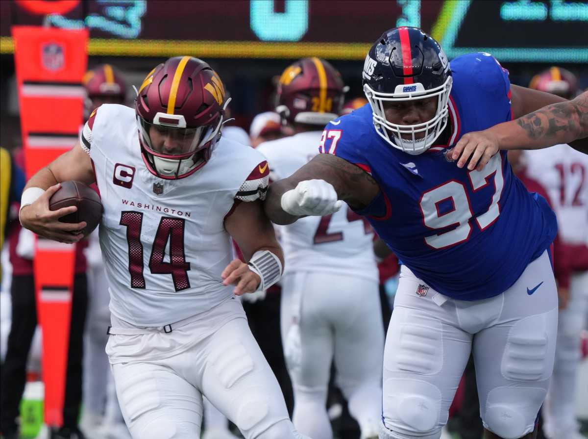 Washington Commanders quarterback Sam Howell is chased by New York Giants defensive tackle Dexter Lawrence on Oct. 22, 2023.