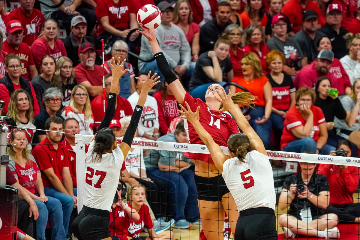 Oct 21, 2023; Lincoln, NE, USA; Wisconsin Badgers middle blocker Anna Smrek (14) attacks against Nebraska Cornhuskers outside hitter Harper Murray (27) and middle blocker Bekka Allick (5) during the second set at the Bob Devaney Sports Center. Mandatory Credit: Dylan Widger-USA TODAY Sports