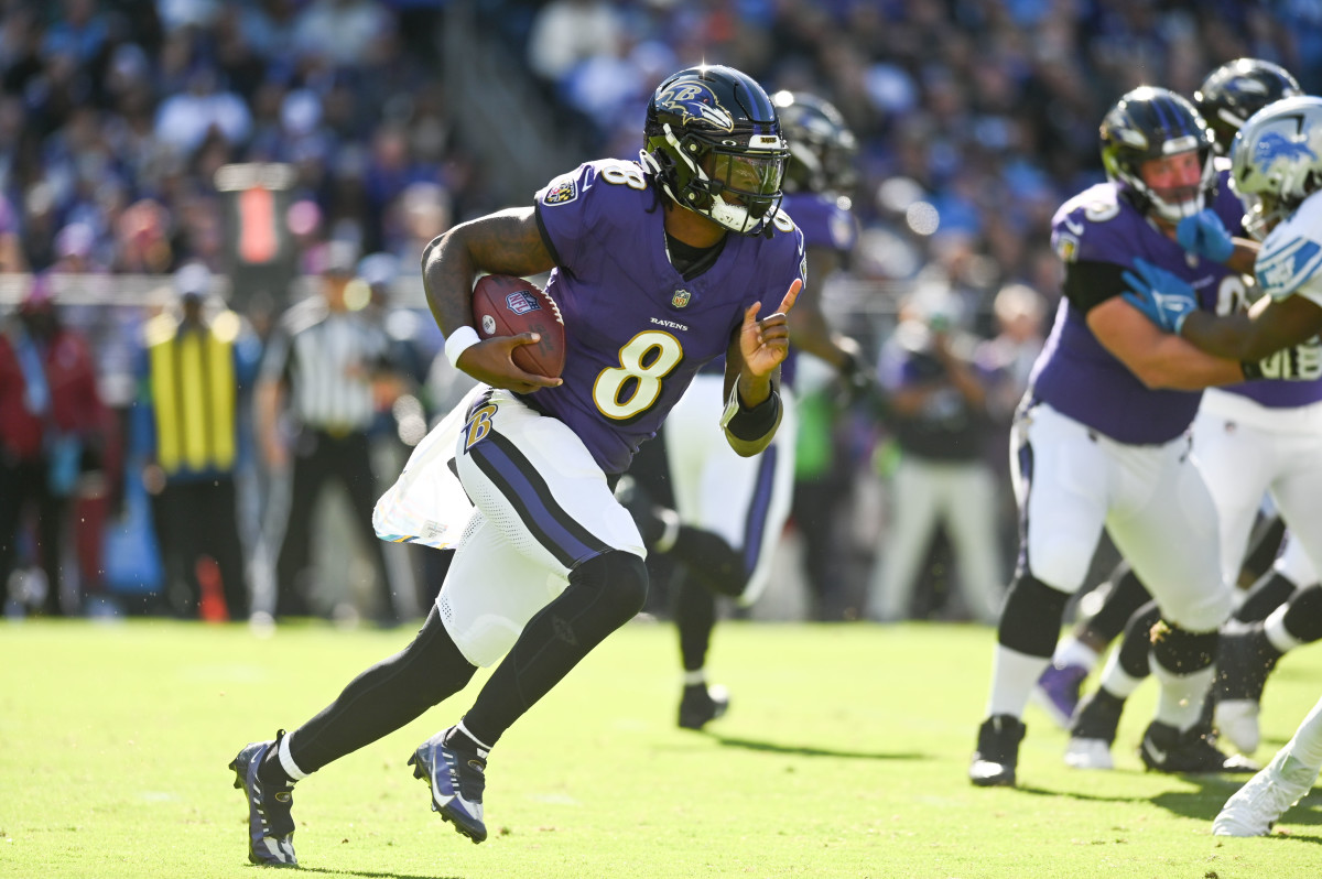Lamar Jackson runs with the ball