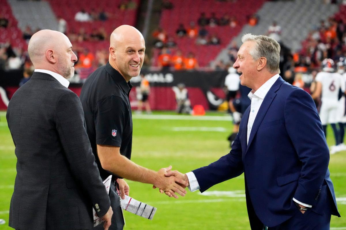 Arizona Cardinals general manager Monti Ossenfort greets broadcaster Ron Wolfley (right) during a preseason game against the Denver Broncos at State Farm Stadium in Glendale on Aug. 11, 2023.