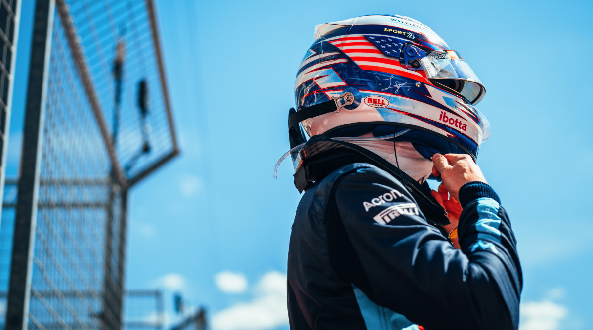 Logan Sargeant of Williams Racing pulls on his helmet at the U.S. Grand Prix.