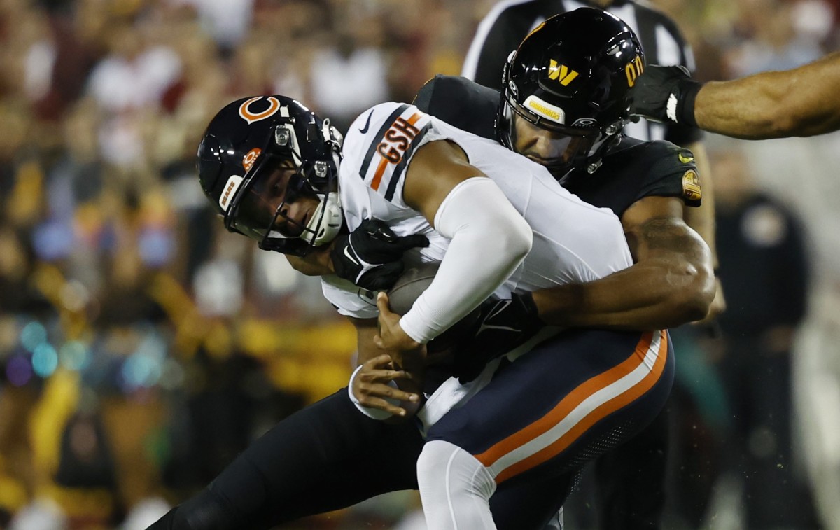 Chicago Bears quarterback Justin Fields (1) is sacked by Washington Commanders defensive end Montez Sweat (90) during the first quarter at FedExField.