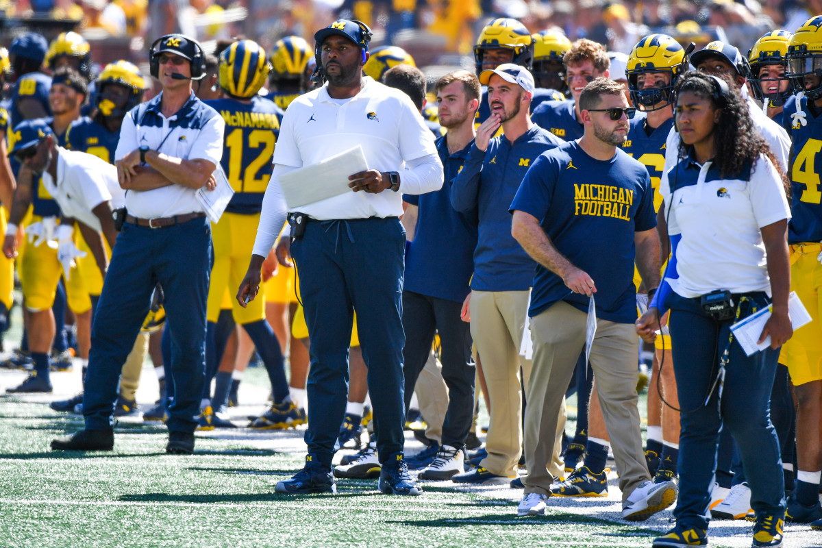 Connor Stalions standing on the Michigan football sideline.