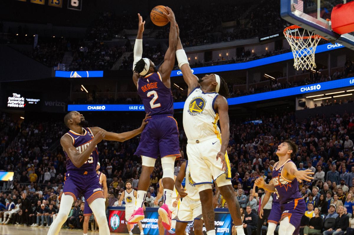 Phoenix Suns guard Josh Okogie (2) outleaps Golden State Warriors forward Kevon Looney (5) for a game-sealing rebound during the fourth quarter at Chase Center.