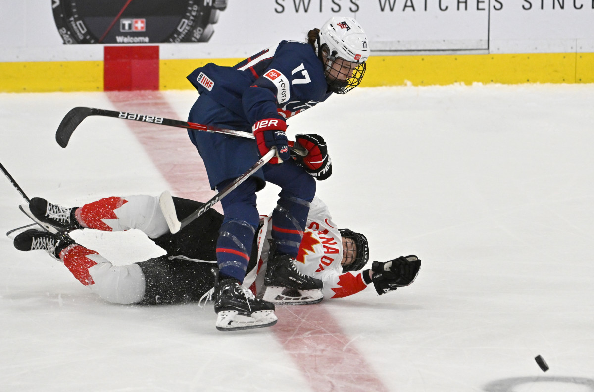 Apr 16, 2023; Brampton, Ontario, CAN; USA forward Britta Curl (17) knocks down Canada defender Ella Shelton (17) as they pursue the puck in the first period at CAA Center. Mandatory Credit: Dan Hamilton-USA TODAY Sports