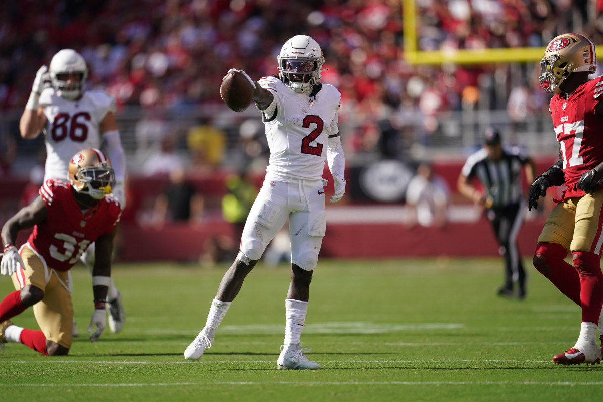 Marquise Brown holds the ball out in celebration as 49ers players look on around him