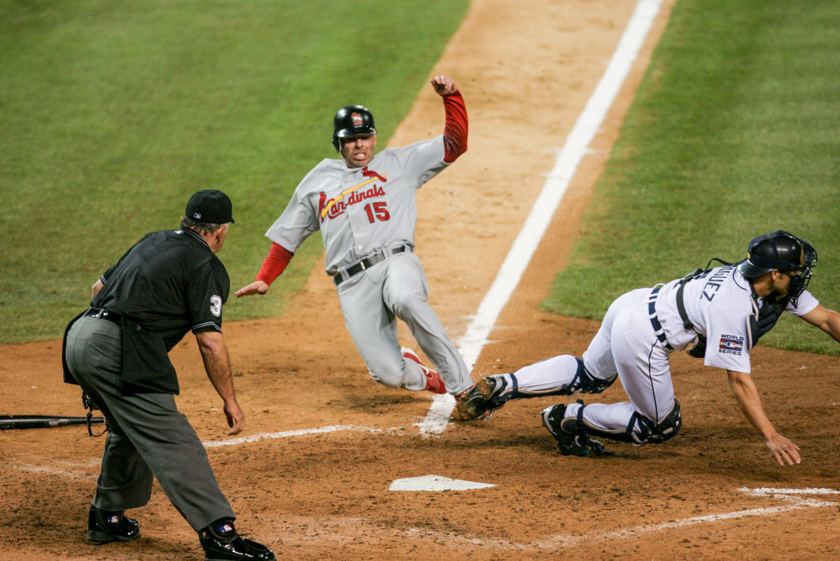 Cardinals outfielder Jim Edmonds slides into home plate as Tigers catcher Ivan Rodriguez tries to field a throw during the 2006 World Series