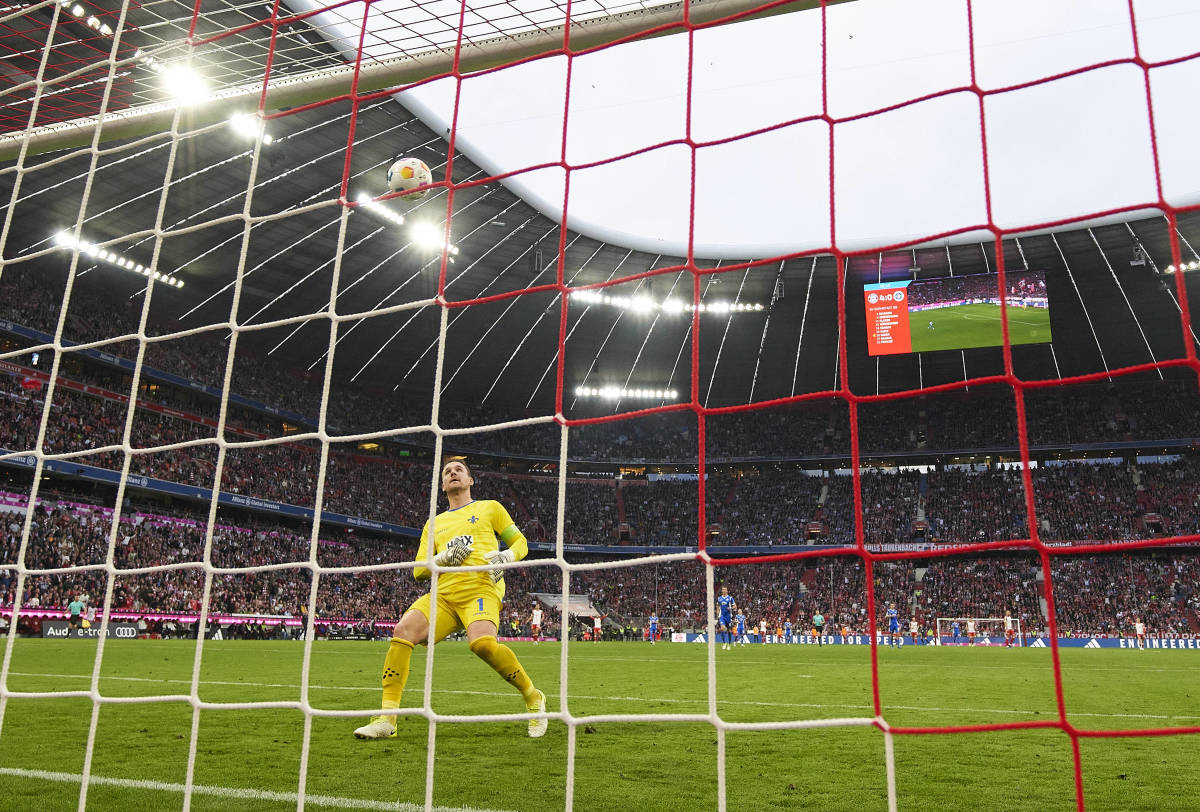 Darmstadt goalkeeper Marcel Schuhen pictured watching on helplessly as a shot by Bayern Munich striker Harry Kane from inside his own half flies into the net during a Bundesliga game in October 2023