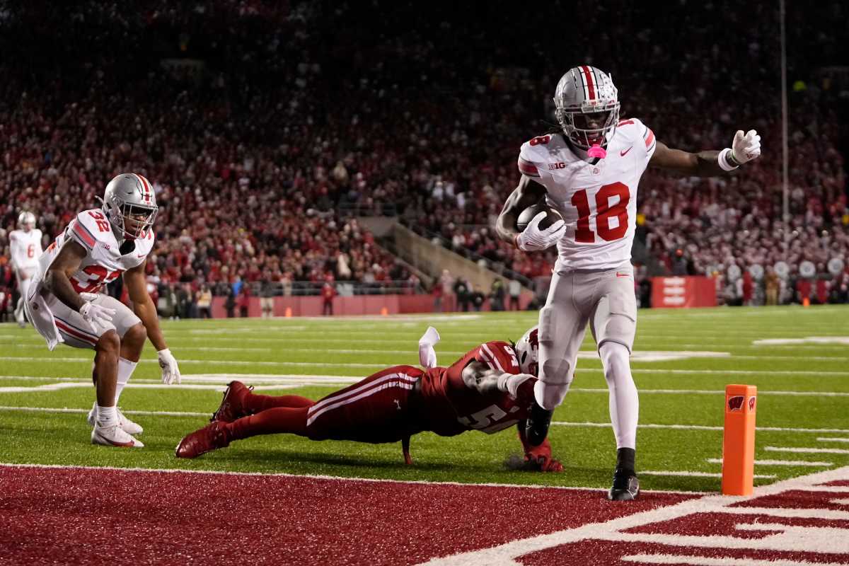 Oct 28, 2023; Madison, Wisconsin, USA; Ohio State Buckeyes wide receiver Marvin Harrison Jr. (18) scores a touchdown in front of Wisconsin Badgers linebacker Jordan Turner (54) during the first half of the NCAA football game at Camp Randall Stadium.