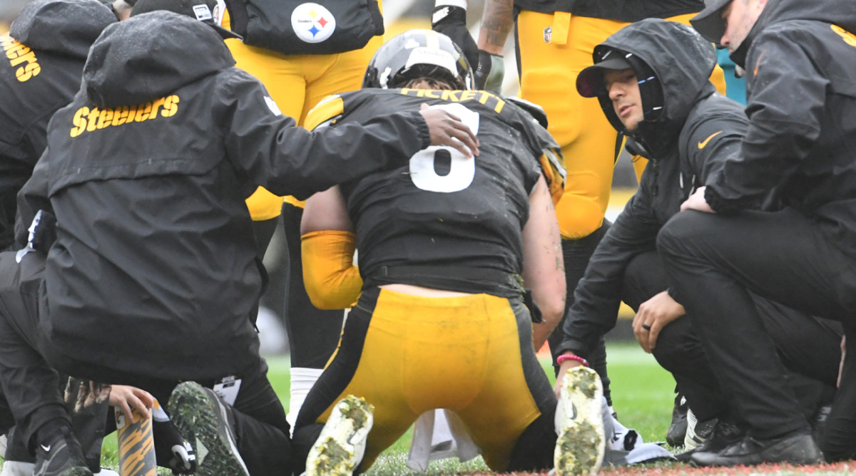 Steelers quarterback Kenny Pickett is attended to on the field after getting hit.