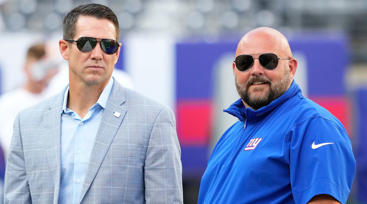 Giants general manager Joe Schoen and coach Brian Daboll talk before a game preseason game. Both are wearing sunglasses.