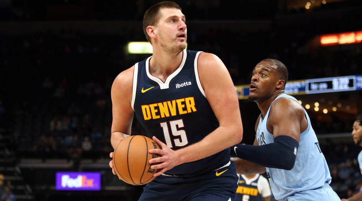 Denver Nuggets center Nikola Jokic  spins toward the basket as Memphis Grizzlies forward Xavier Tillman defends.