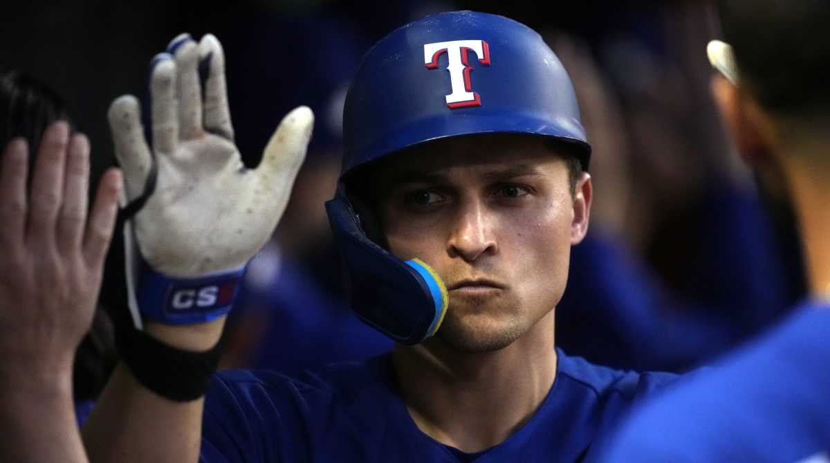 Corey Seager sports a stoic face as he is congratulated by teammates in the dugout after hitting a home run in Game 3 of the 2023 World Series.