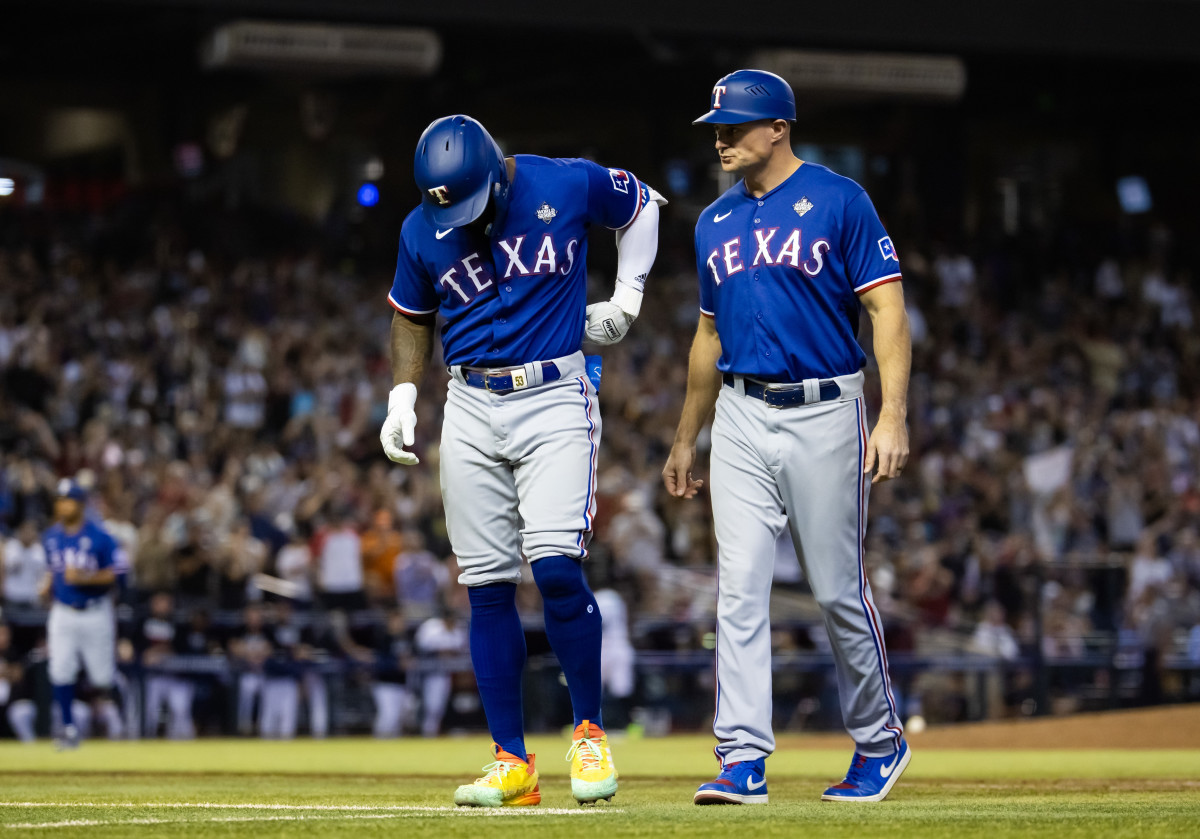 Oct 30, 2023; Phoenix, AZ, USA; Texas Rangers right fielder Adolis Garcia (left) reacts alongside first base coach Corey Ragsdale after after suffering an injury in the eighth inning of game three of the 2023 World Series against the Arizona Diamondbacks at Chase Field. Mandatory Credit: Mark J. Rebilas-USA TODAY Sports