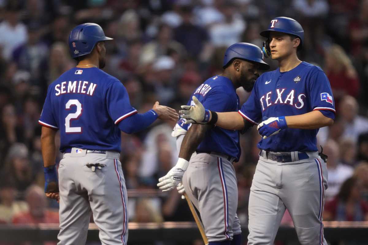 Texas Rangers shortstop Corey Seager (right) is congratulated by second baseman Marcus Semien (2) after hitting a two-run home run against the Arizona Diamondbacks during the third inning in game three of the 2023 World Series at Chase Field on Oct. 30, 2023, in Phoenix, Arizona.