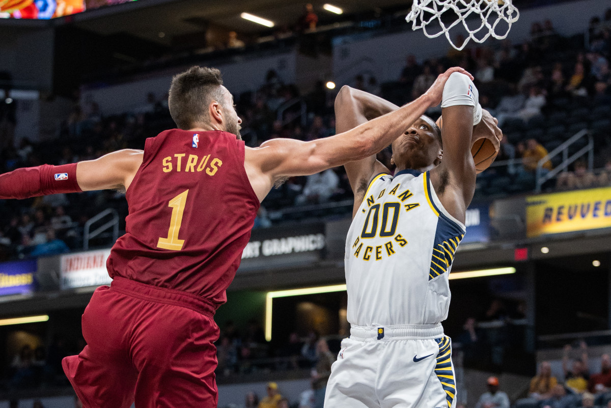 Max Strus puts his arm out to defend as a Pacers player shoots the ball